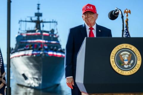 President Trump, in a red USA hat, at the podium at Sparrows Point Shipyard in Baltimore, Maryland, where Anduril Industries will build a submarine and autonomous vessel shipyard, October 6, 2026 (Official White House Photo by Daniel Torok)
