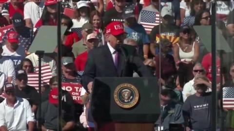 President Trump speaks at a podium bearing the presidential seal before a packed crowd at his rally in Bullhead City, Arizona, October 14, 2026 (still from Rapid Response 47 video)