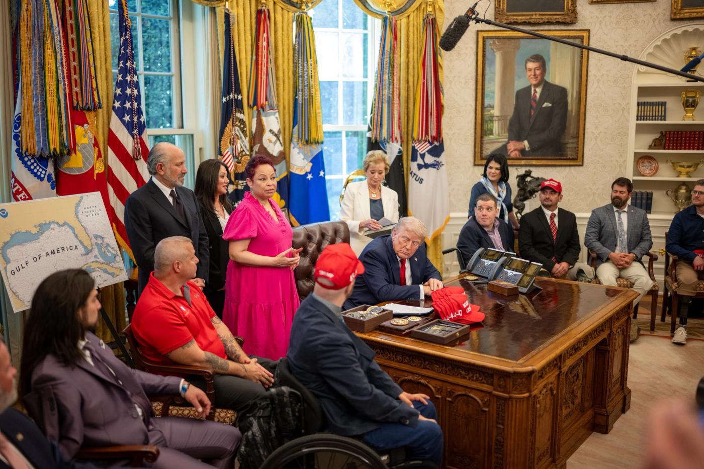 President Trump at the Resolute Desk with Secretary of Education Linda McMahon (woman in the white blazer behind the desk) and wounded warriors, Oval Office, April 23, 2025. Official White House Photo by Daniel Torok. Not the September 30, 2026 Defaulted Loans Support Center launch. Treasury Secretary Bessent is not in this frame.