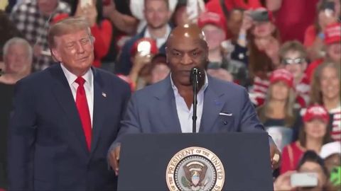 Mike Tyson speaks at the presidential lectern as President Trump stands beside him on stage at his rally in Syracuse, New York, October 9, 2026 (still from Official White House video)