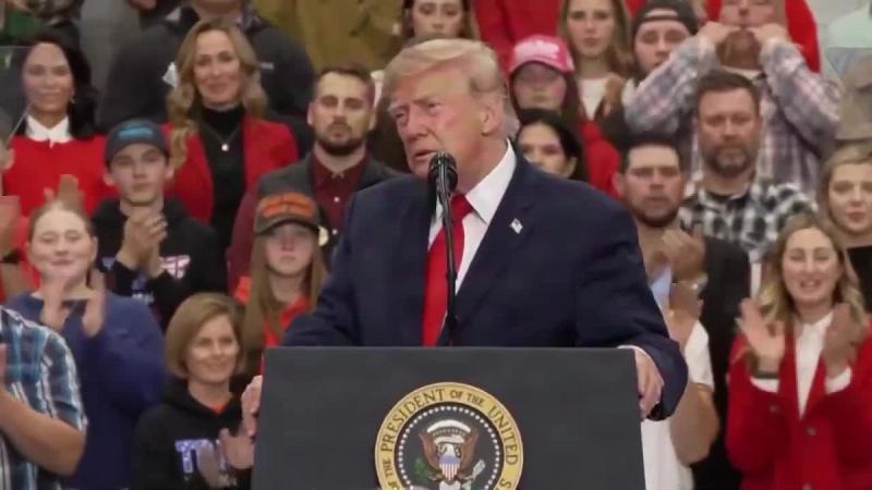 President Trump speaks at a podium bearing the presidential seal as supporters applaud behind him at his rally in Wasilla, Alaska, October 13, 2026 (still from Rapid Response 47 video)