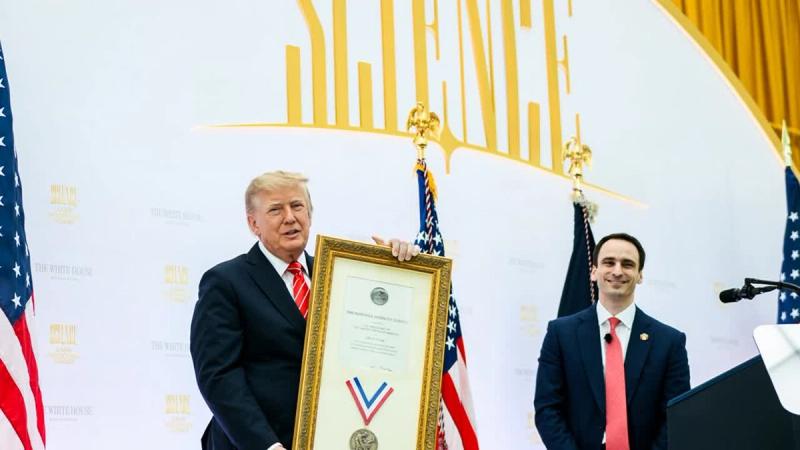 President Trump holds the framed National Medal of Science awarded to his uncle, Dr. John G. Trump, beside OSTP Director Michael Kratsios at the Science: A New Golden Age Summit, October 8, 2026 (Official White House photo)