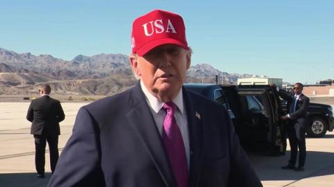 President Trump, in a red USA cap and navy suit, speaks to reporters on the tarmac before departing Bullhead City, Arizona, October 14, 2026 (still from Rapid Response 47 video)