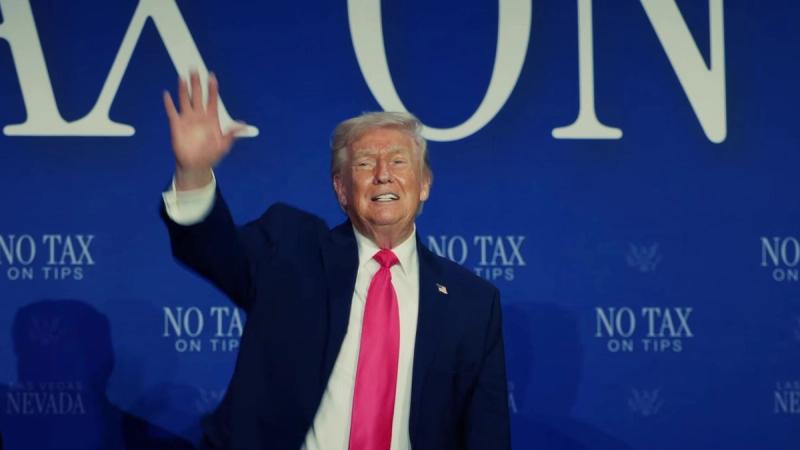 President Trump smiles and waves in front of a No Tax on Tips backdrop reading Las Vegas, Nevada, a scene from the White House video “No Tax on Overtime: Promises Made, Promises Kept,” released October 11, 2026