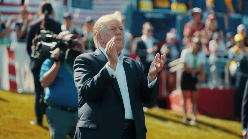 President Trump applauds outdoors before a crowd of Patriots under American flags (still from Official White House video “16 Months of Zero Releases at The Border”)