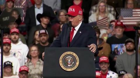President Donald J. Trump, wearing a red USA cap, speaks at a lectern bearing the presidential seal at his rally in Montana, October 14, 2026 (still from Rapid Response 47 video)