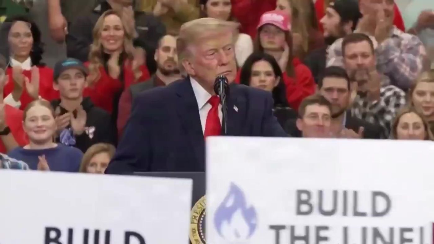 President Trump speaks at the Wasilla, Alaska midterm rally with BUILD THE LINE Alaska LNG signs in the foreground, October 13, 2026 (still from Rapid Response 47 video)
