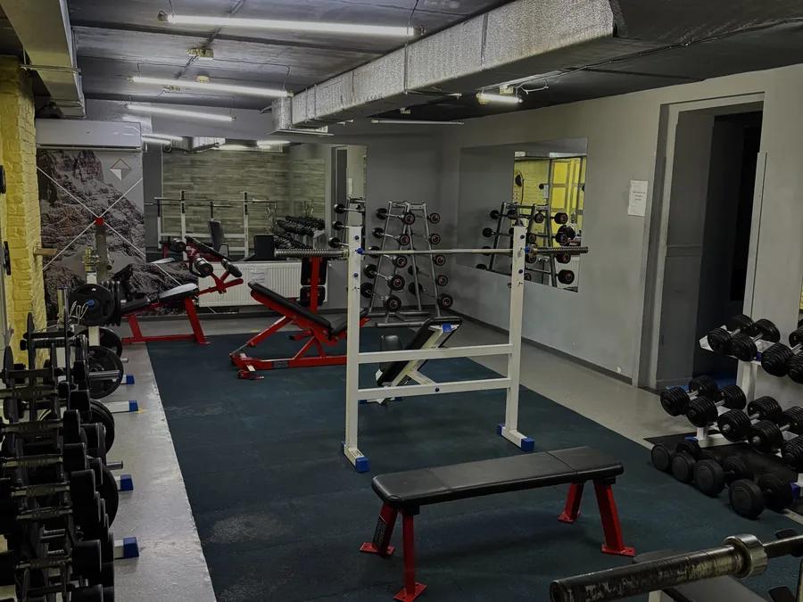Зона вільних ваг: штанги, стійки, лави