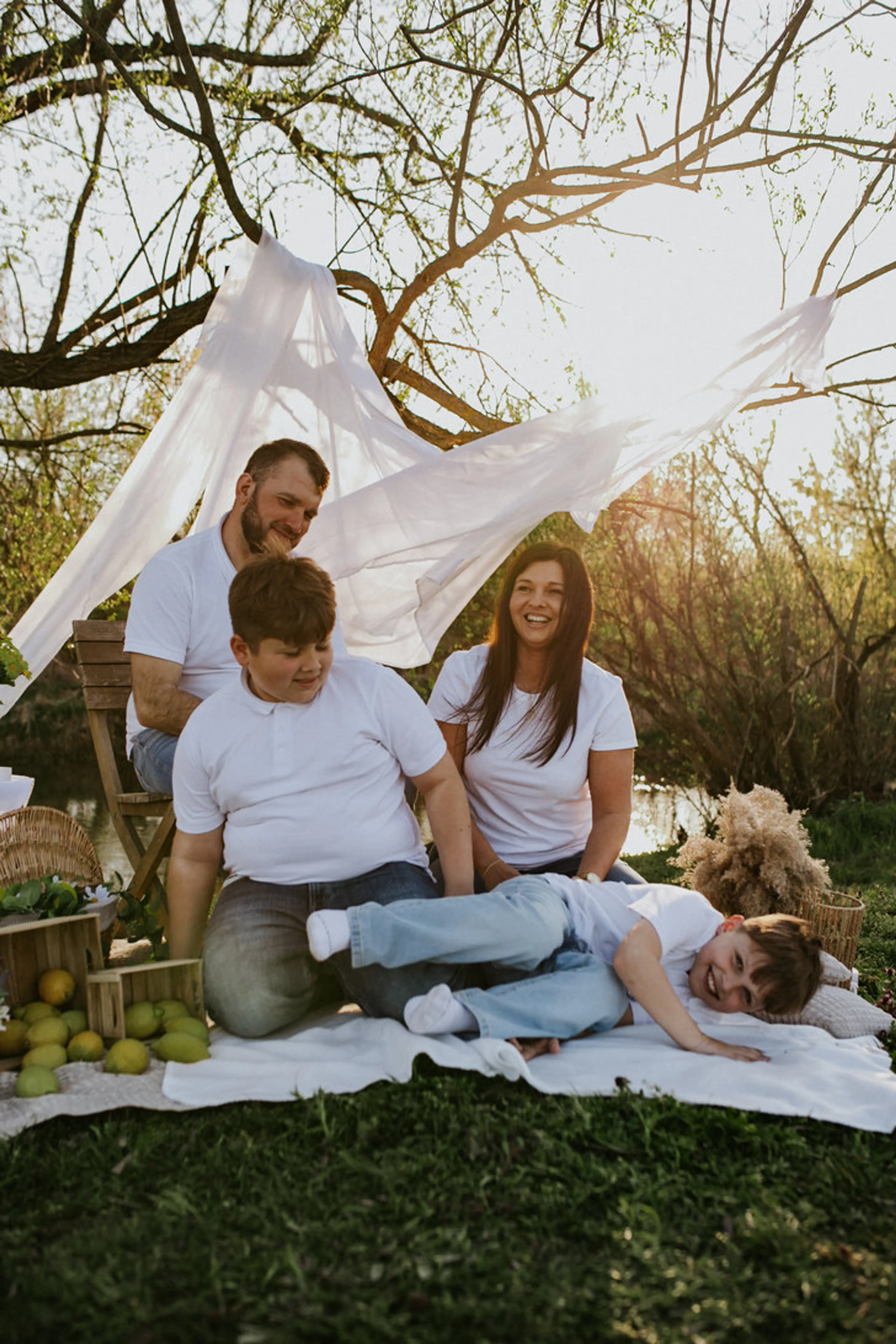 Rodzina z dwójką dzieci podczas swobodnej sesji fotograficznej w plenerze.
