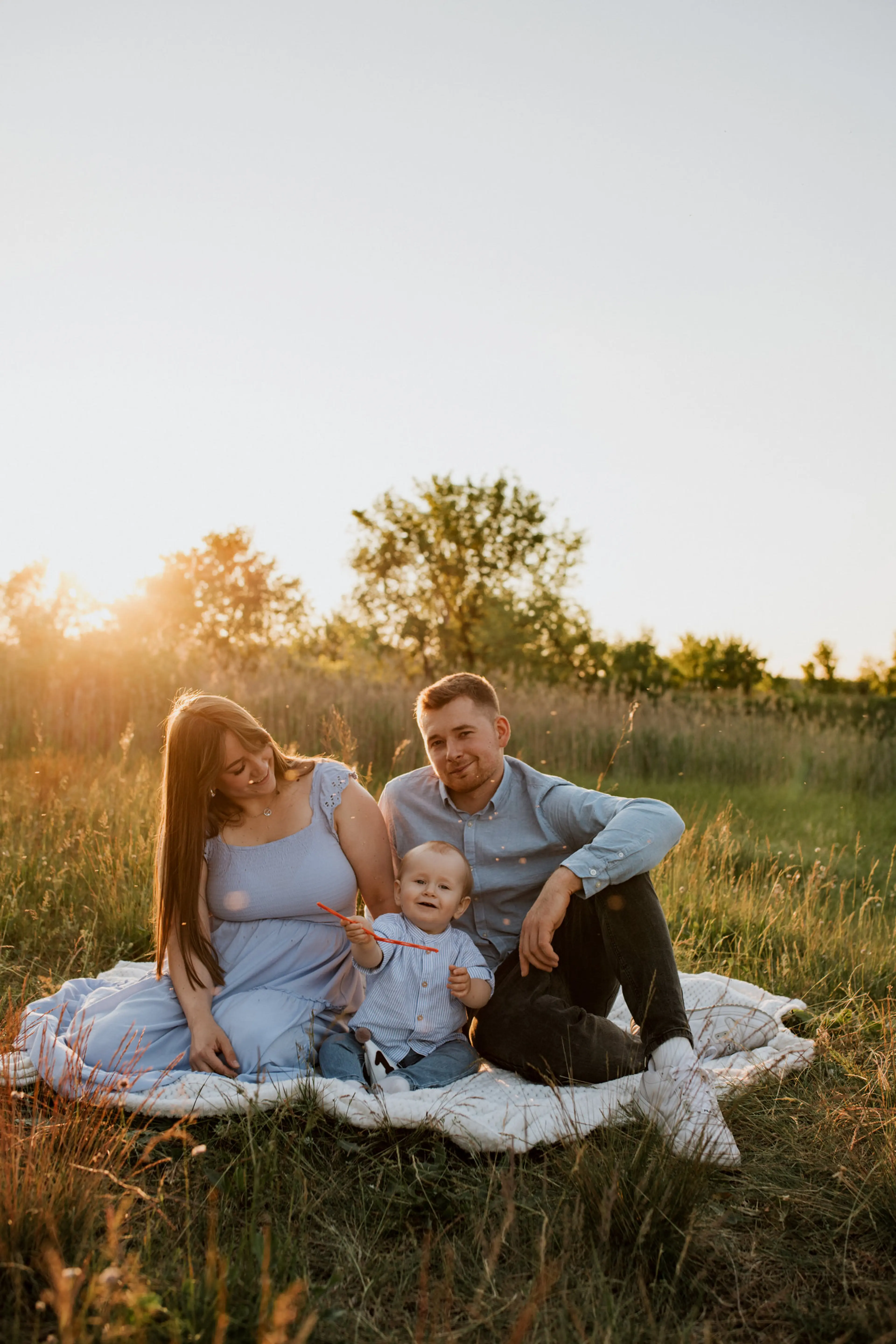 Rodzina z dwójką dzieci podczas swobodnej sesji fotograficznej w plenerze.