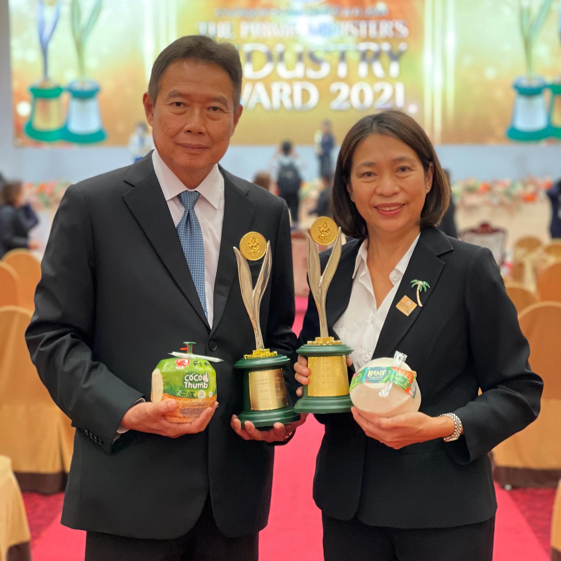  Executives hold trophies and coco thumbs.