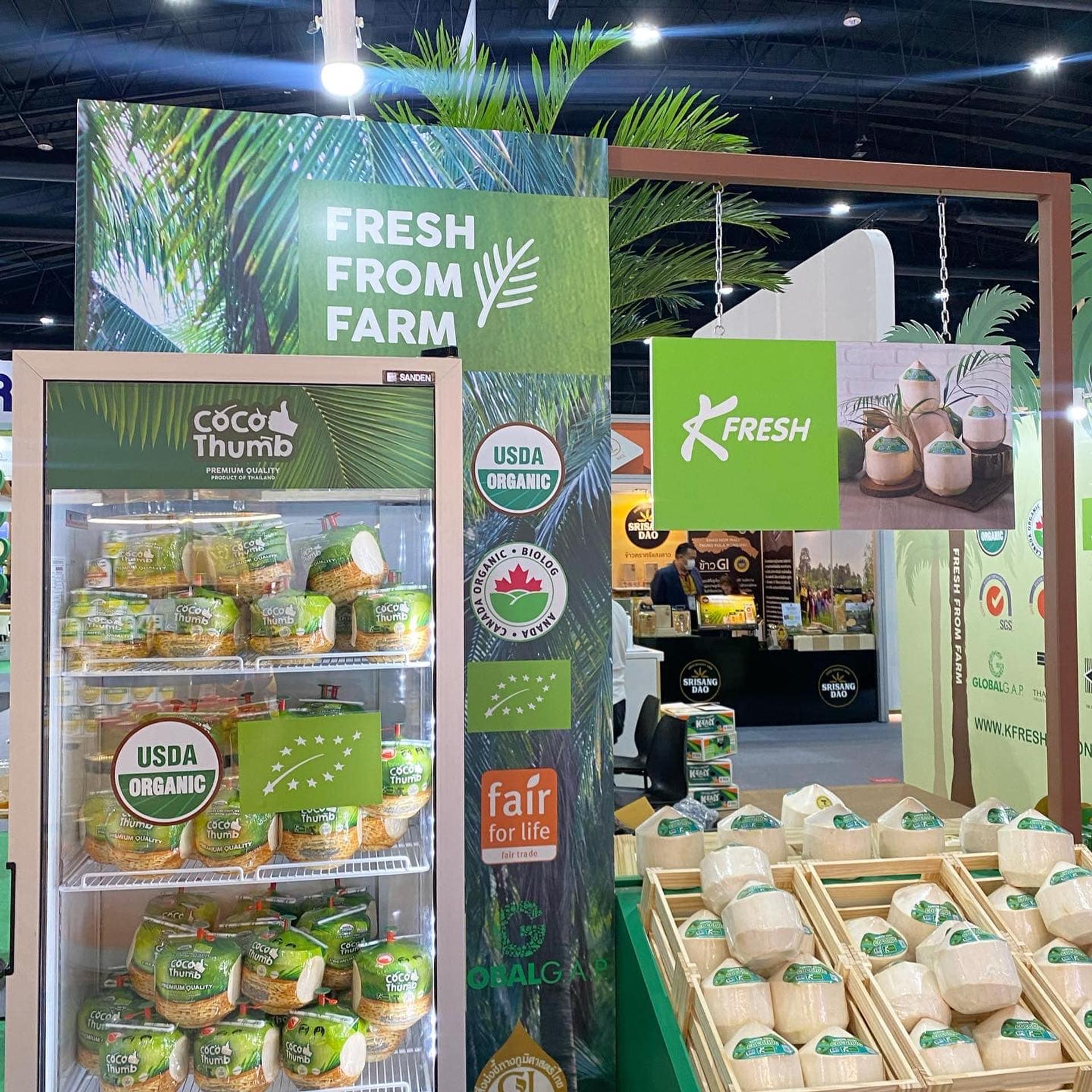 K fresh's refrigerator is full of green coconuts and next to the refrigerator is a white coconut.