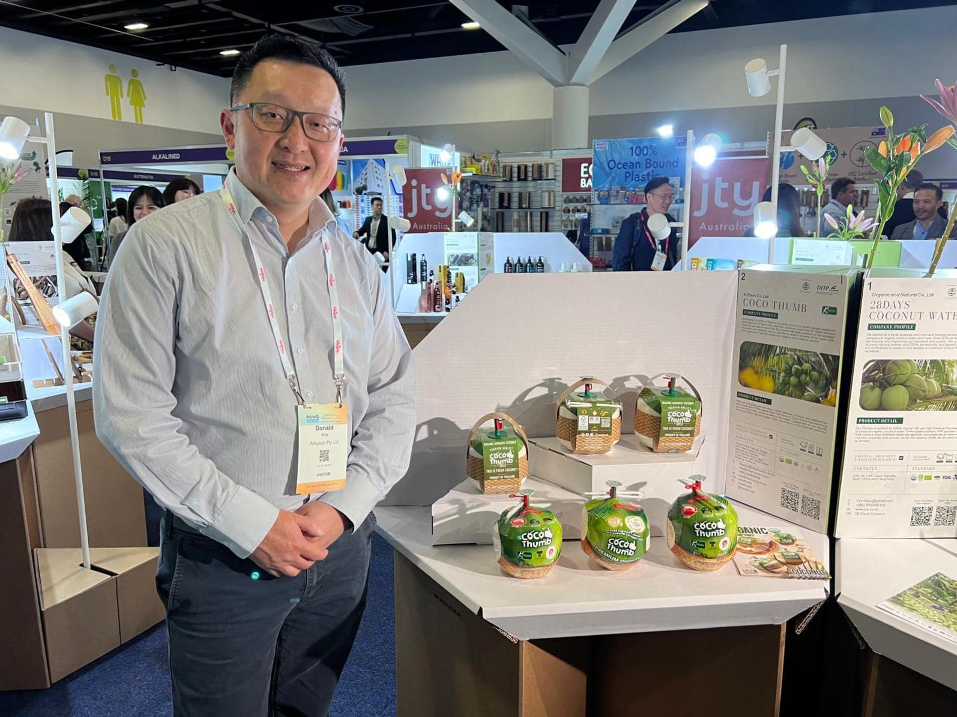 People standing next to the table displaying coconuts