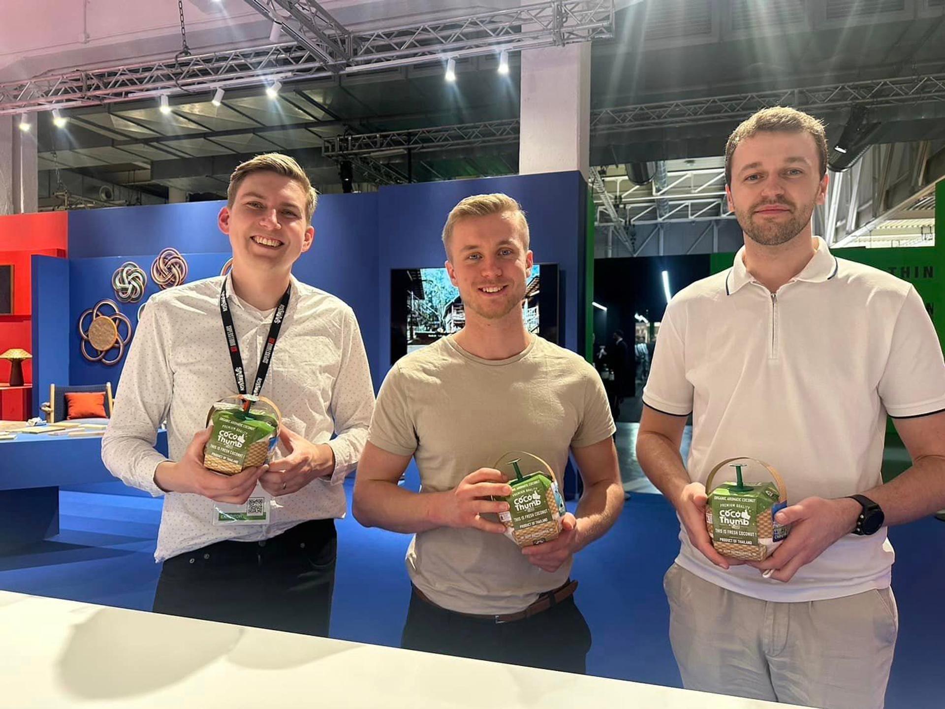 Three men holding coconut water
