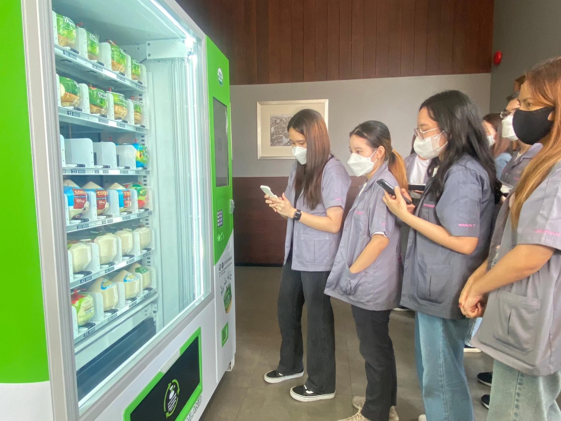Students admire the coconut water vending machine.