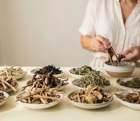 Radici ed erbe essiccate in piccole ciotole di ceramica.