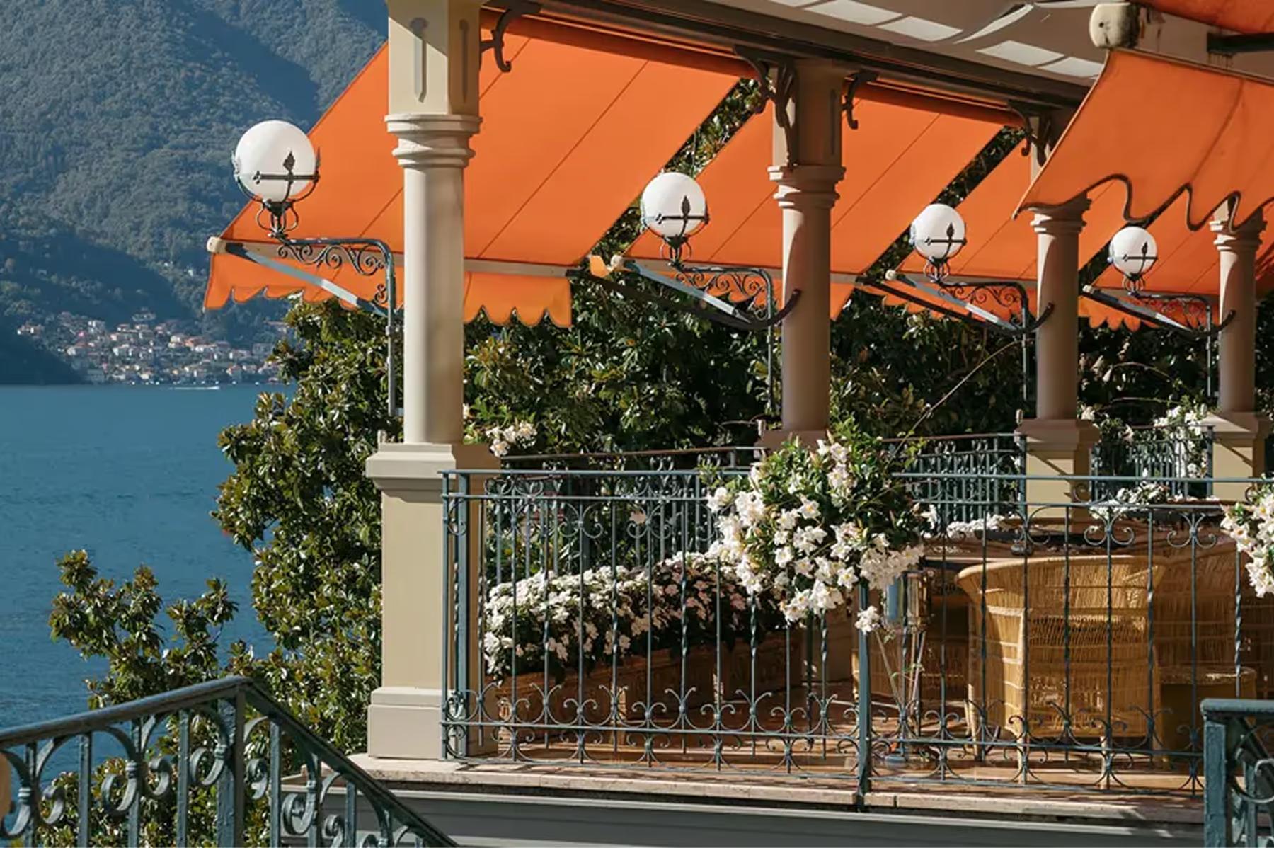 Terrace with orange umbrellas and white posts overlooking the lake