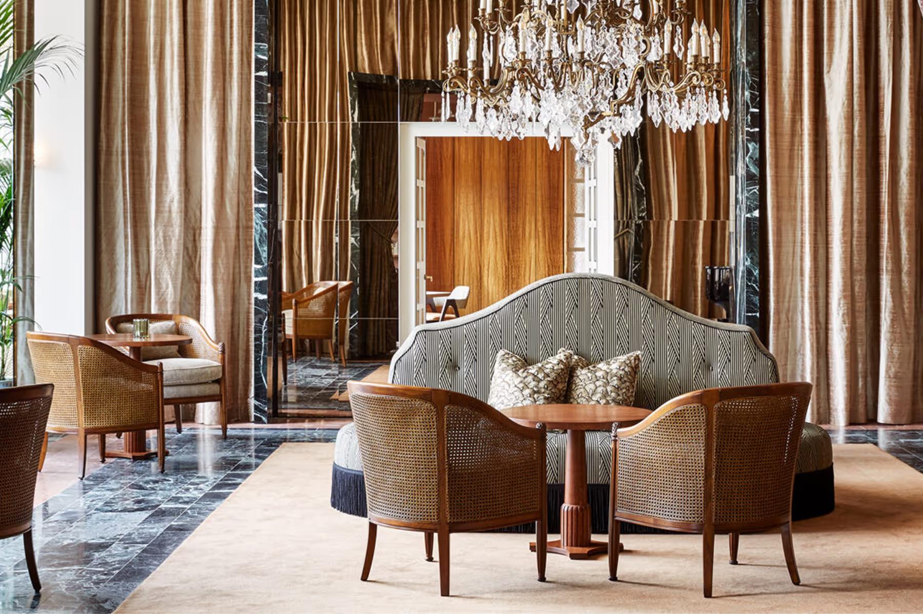 De L’Europe Amsterdam: bedroom with four-poster bed, green velvet upholstered seating, and chandeliers