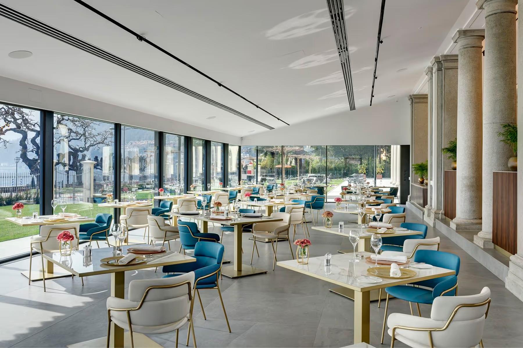 Grand Hotel Victoria Concept & Spa: a formal dining room with white columns, tall windows, and blue accent chairs