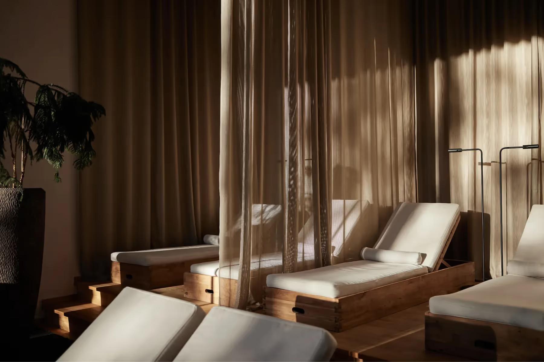 Hotel Saltus: spa lounge area with wooden sun beds and floor-to-ceiling windows casting dramatic light