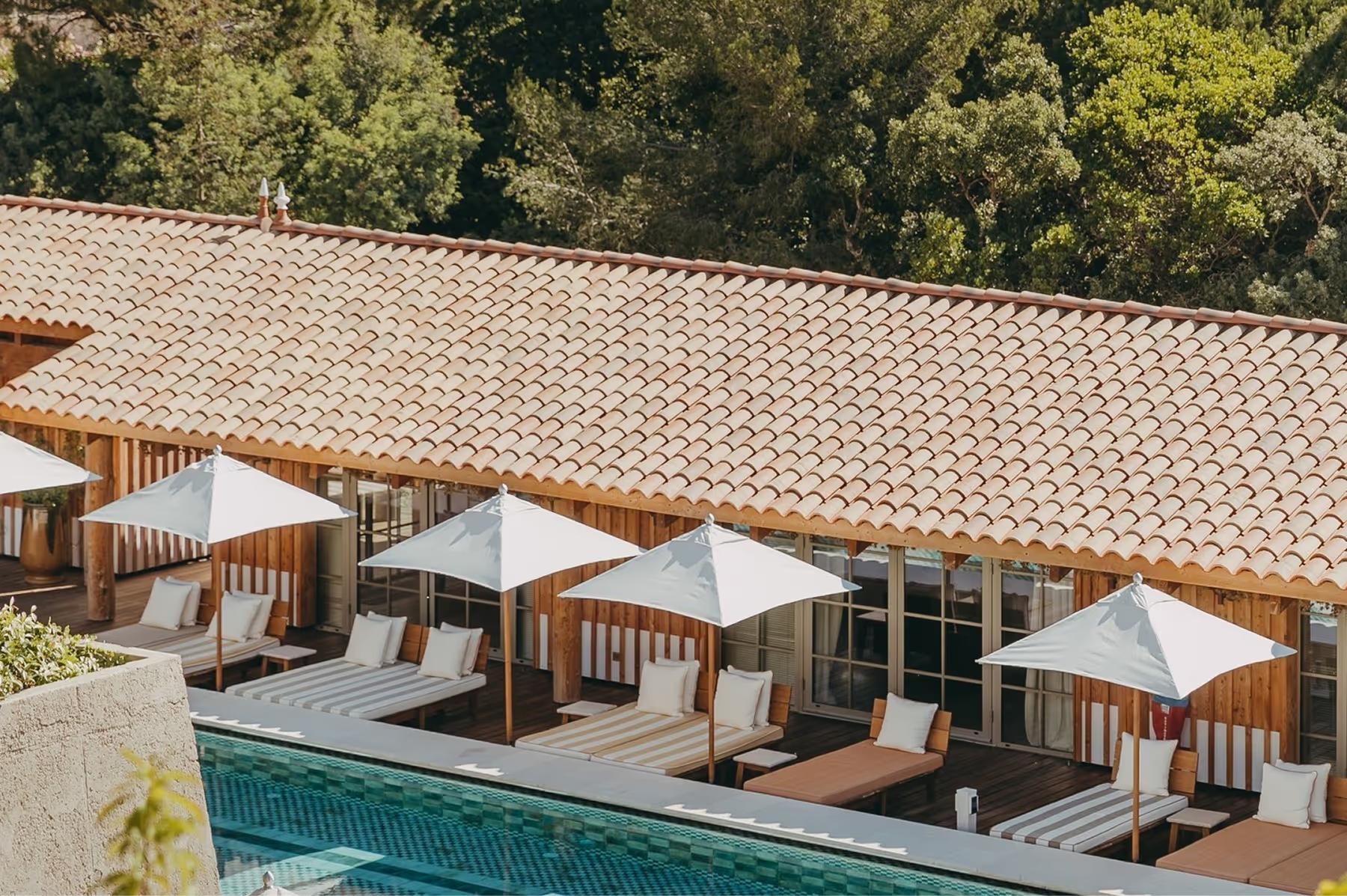 Lily of the Valley: pool area with cabanas and daybeds overlooking forested hillside