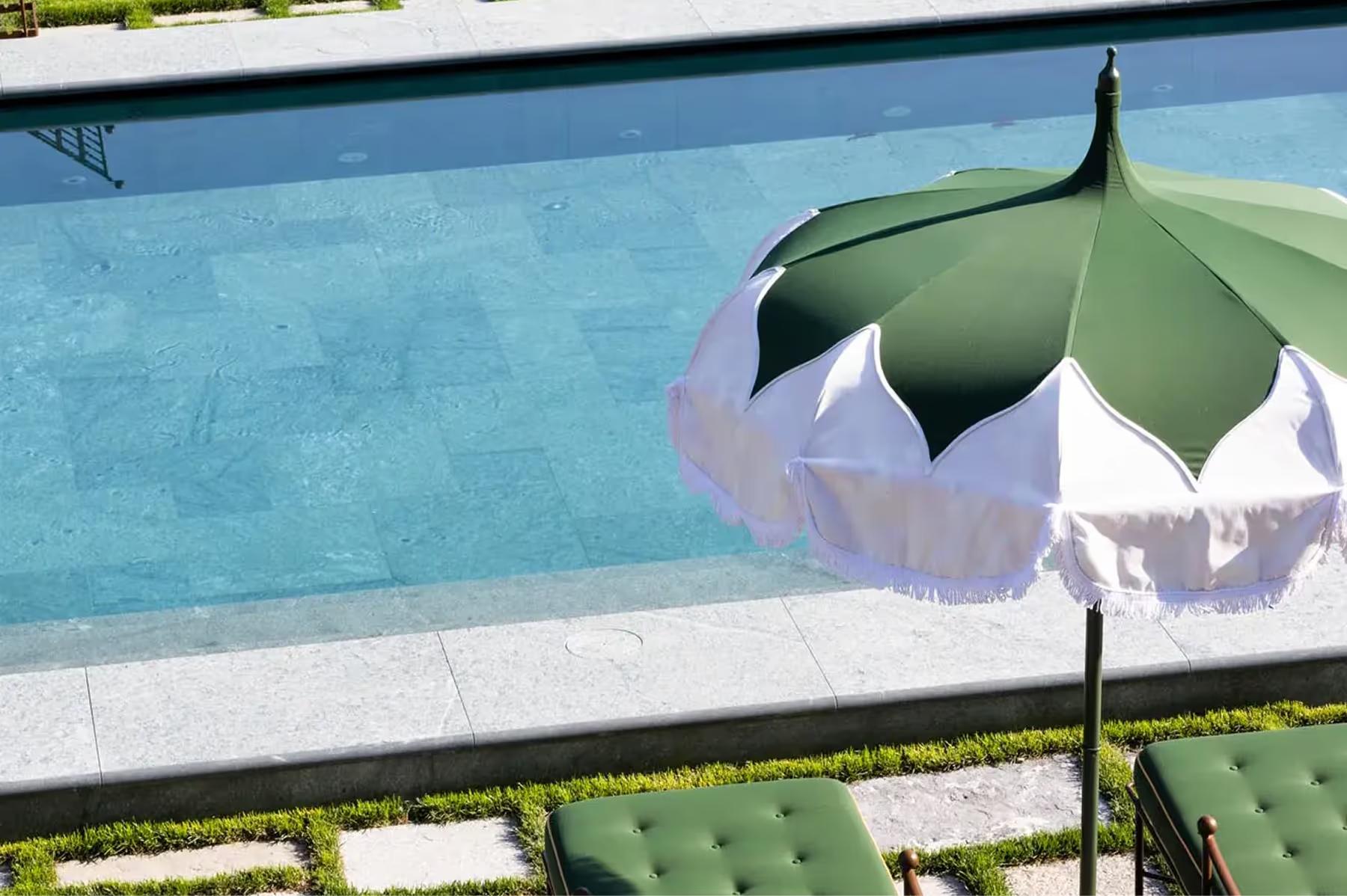 Passalacqua: a pool edge detail with striped umbrella and green interior tile visible