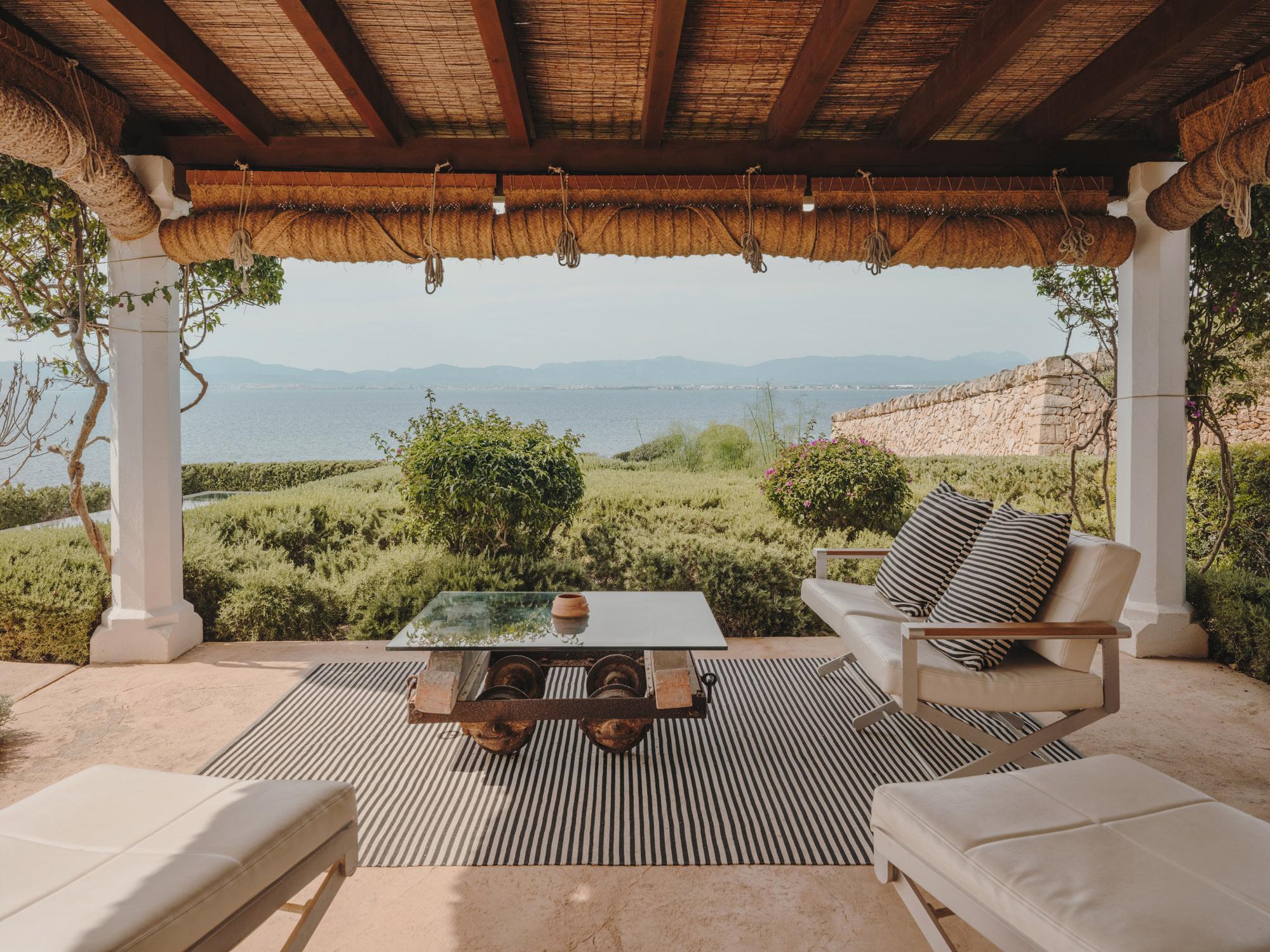 A terracotta villa facade set in golden-hour light, framed by cypress landscaping