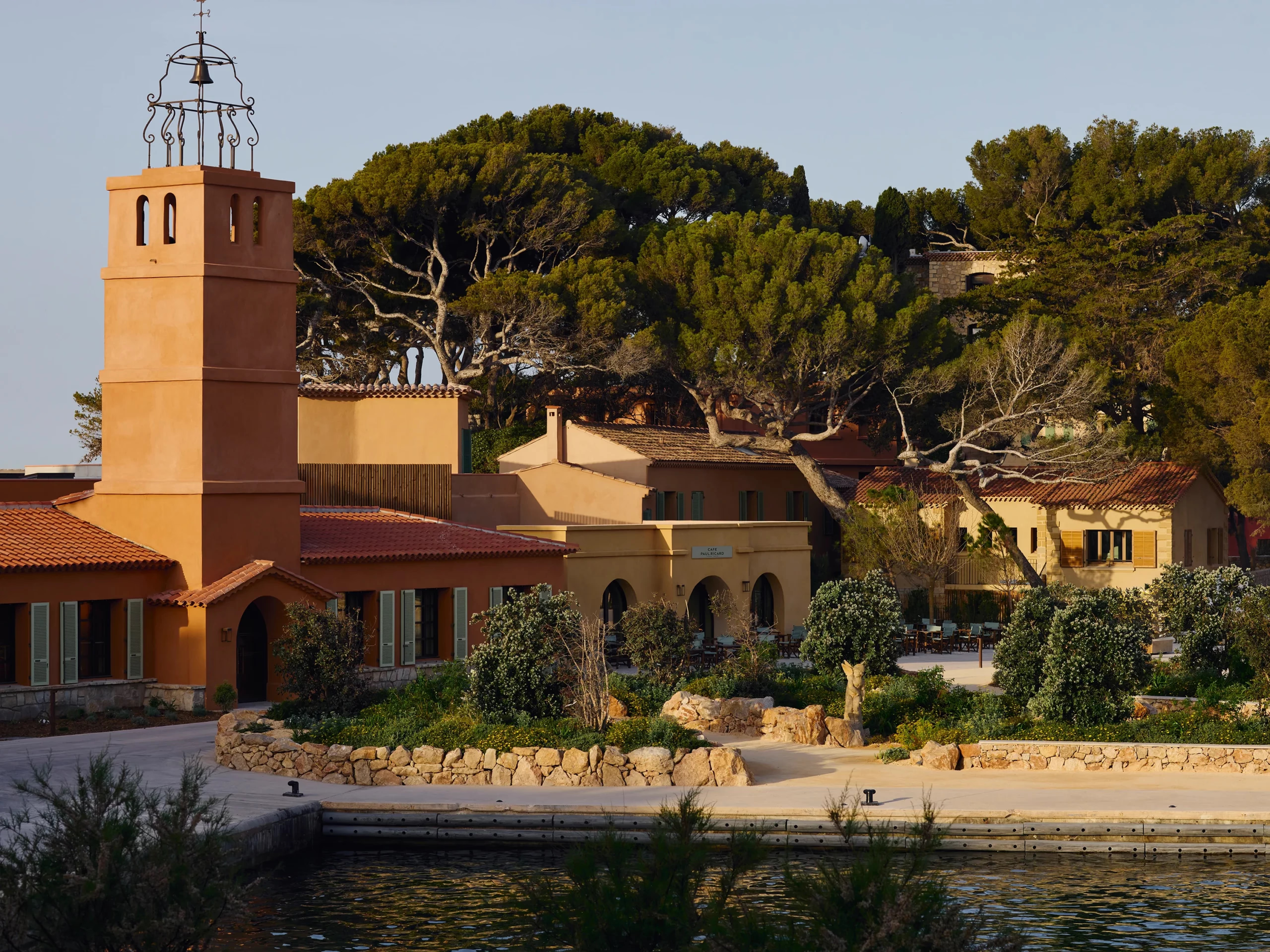 Zannier Île de Bendor: the terracotta bell tower and Café Paul Ricard rise above the harbor among umbrella pines