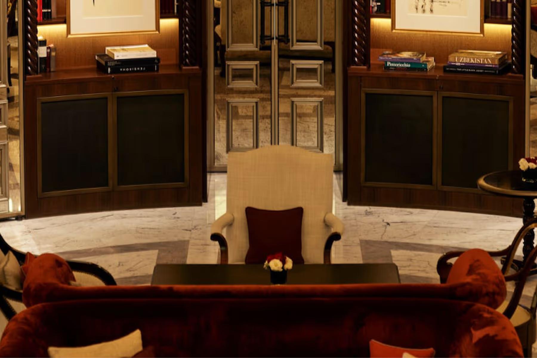 A lounge area with dark wood cabinetry, fireplace, and decorative shelving with books and objects