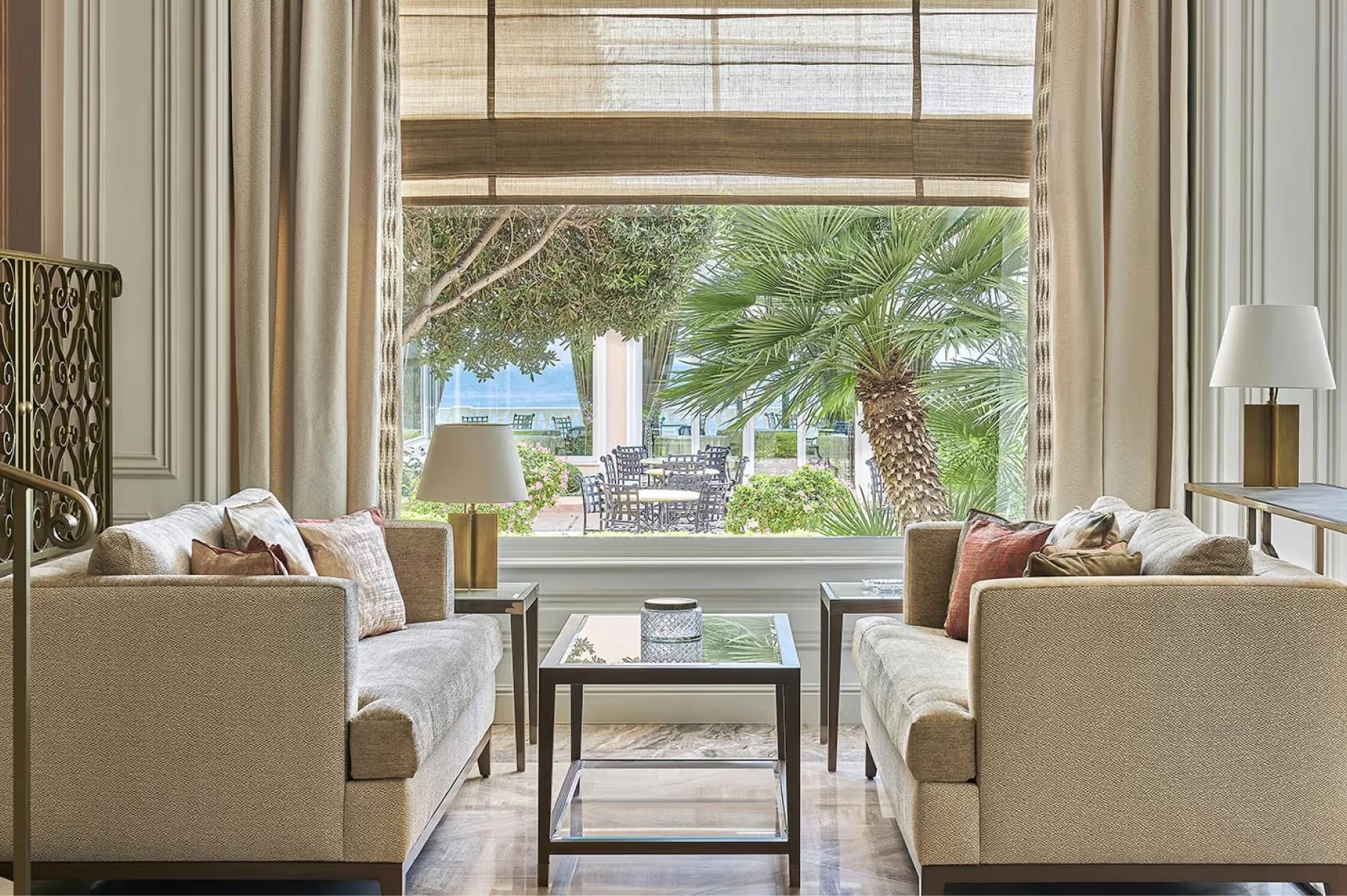 La Réserve de Beaulieu: lounge area with floor-to-ceiling windows overlooking green gardens
