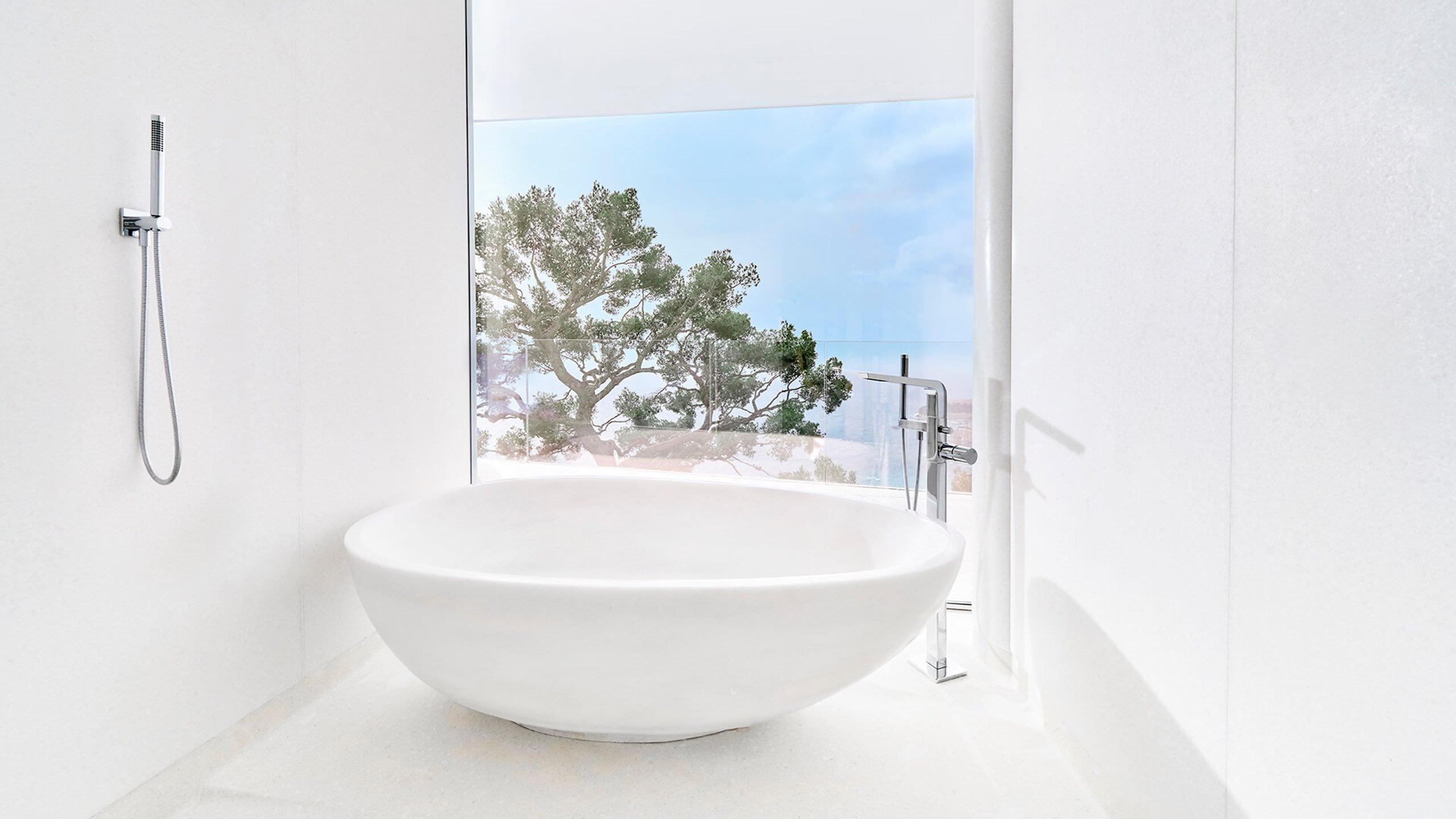 Soaking tub in white with ocean view through window
