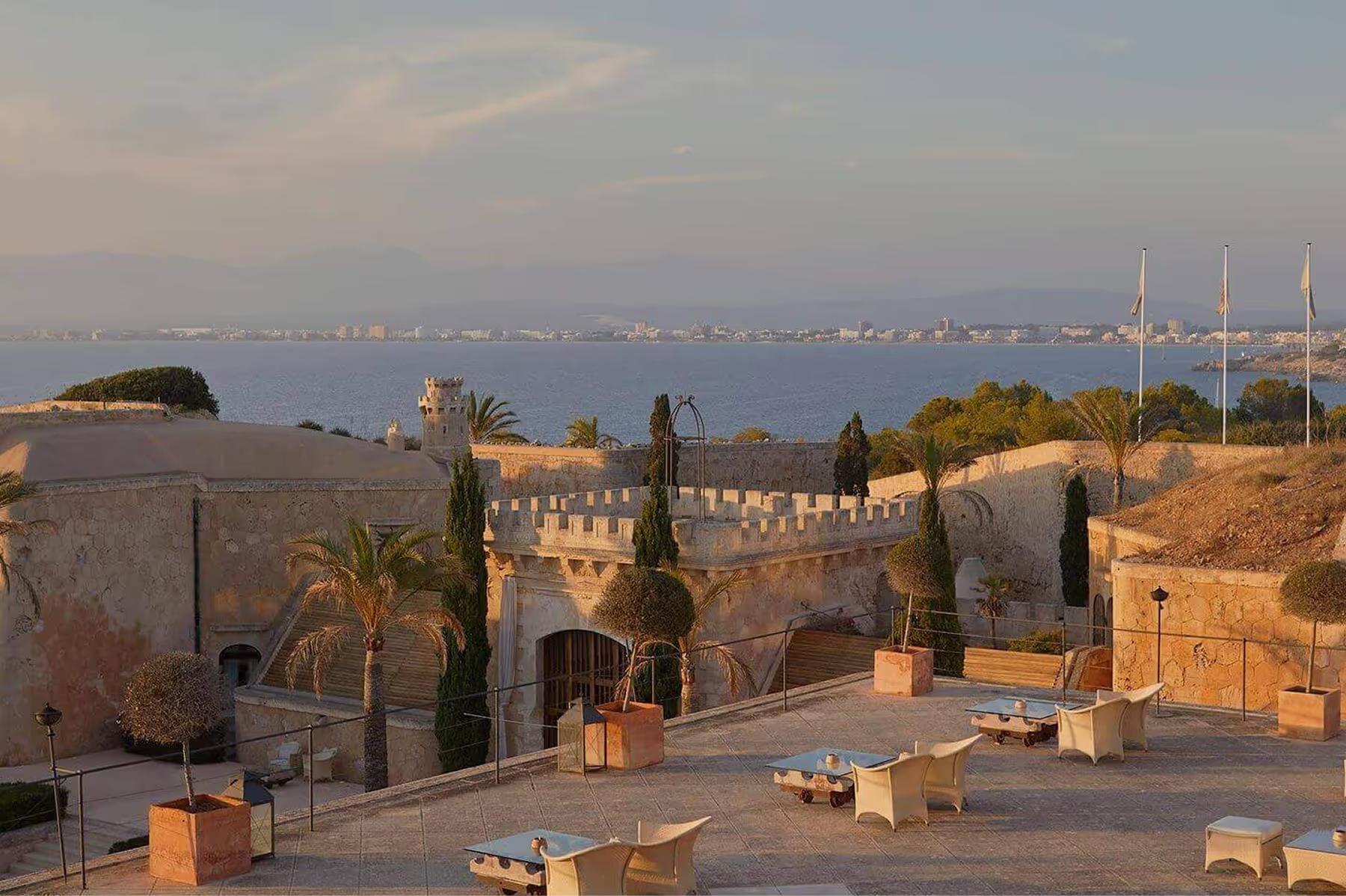 Cap Rocat: a hilltop fortress silhouetted at sunset, with panoramic bay views and cypress sentries