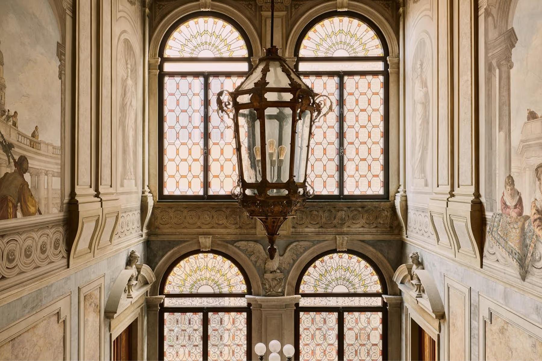 Aman Venice: classical arched windows with columns and lanterns in the palazzo interior courtyard