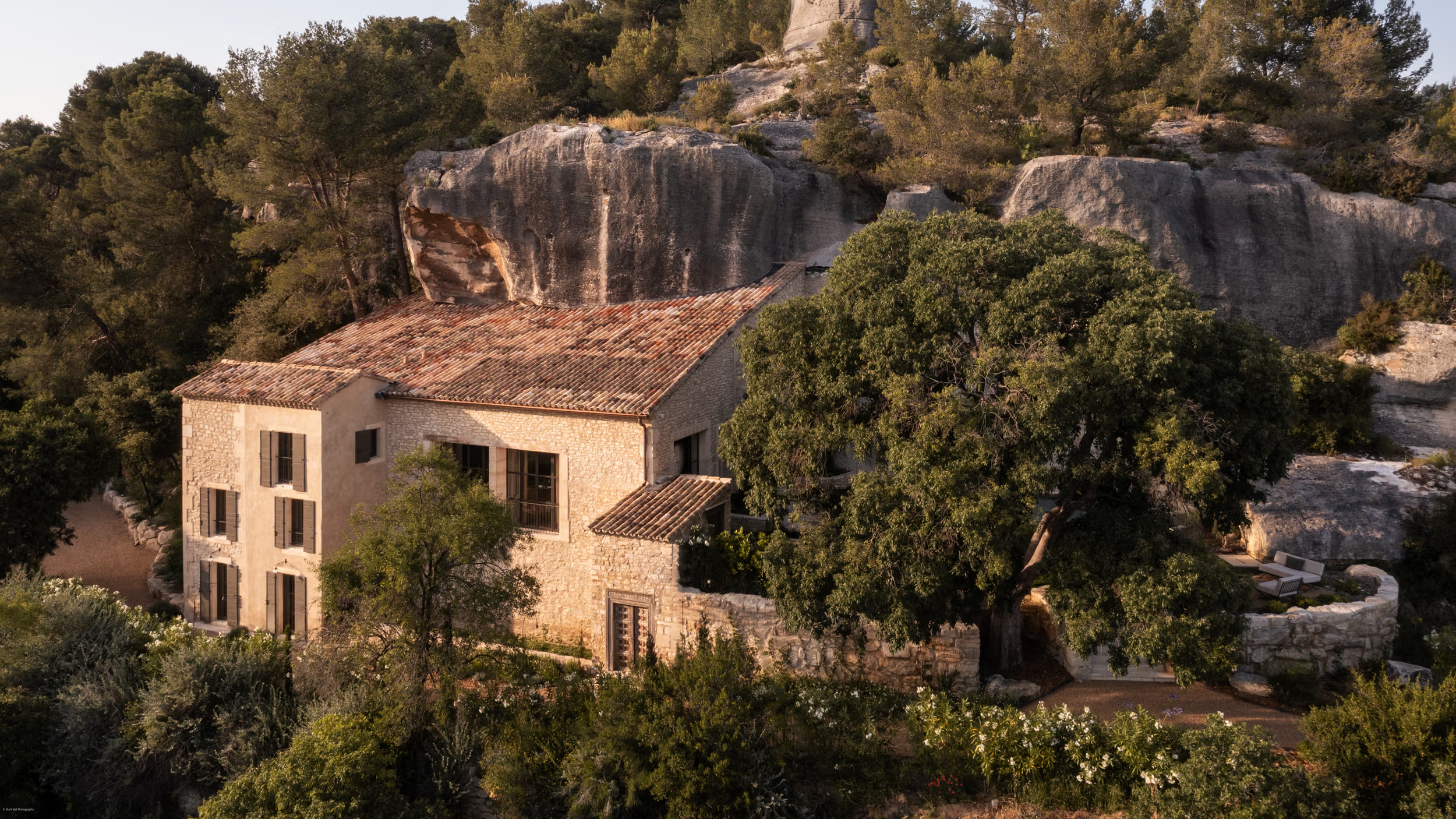 La Bergerie: stone villa set among cypress and olive trees amid soaring limestone rock formations, forested hillside