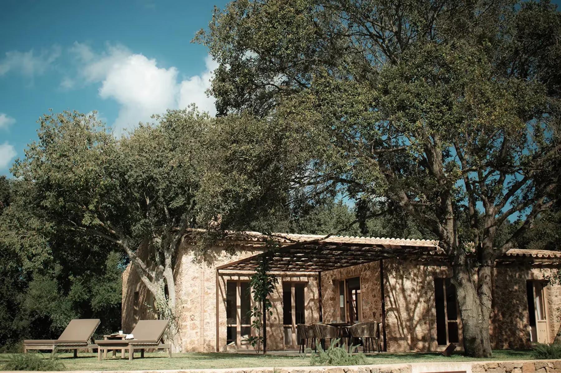 Es Racó d’Artà: traditional stone casita building set in wooded valley landscape with bright Mediterranean light