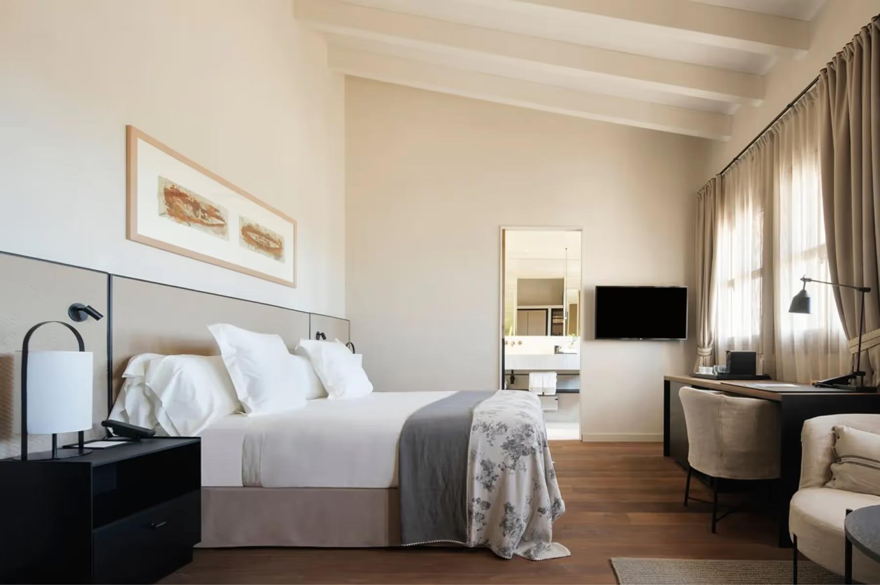 Can Ferrereta: bedroom with queen bed, wooden floors, and dual nightstands in neutral tones