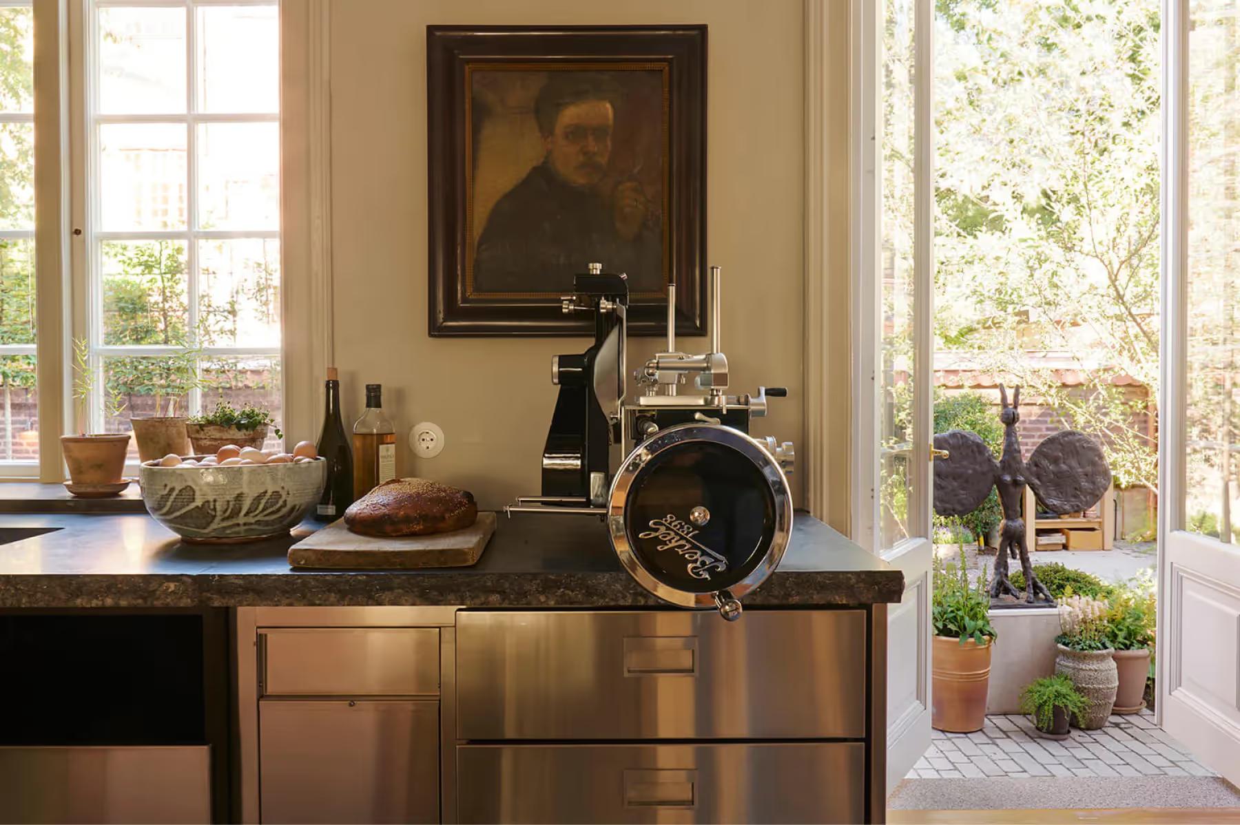 Ett Hem: a desk with a wooden top near windows with classical artwork and garden views