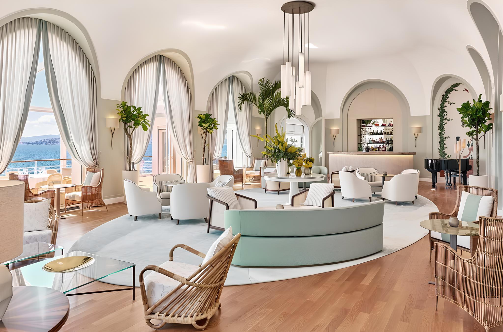 Hôtel du Cap-Eden-Roc: a light-filled circular reception hall with curved seating, arched doorways, and sea-view windows