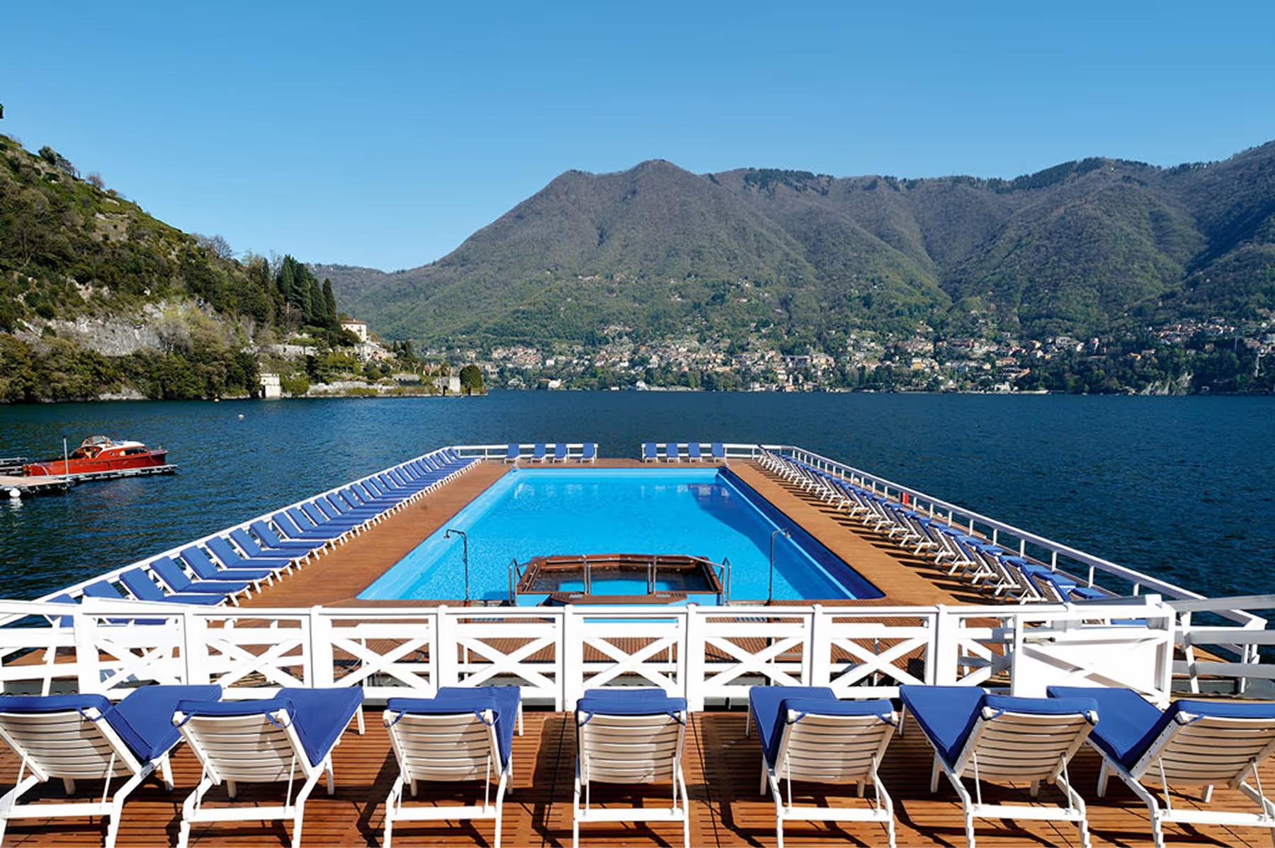 Floating pool platform extending into the lake with mountain backdrop