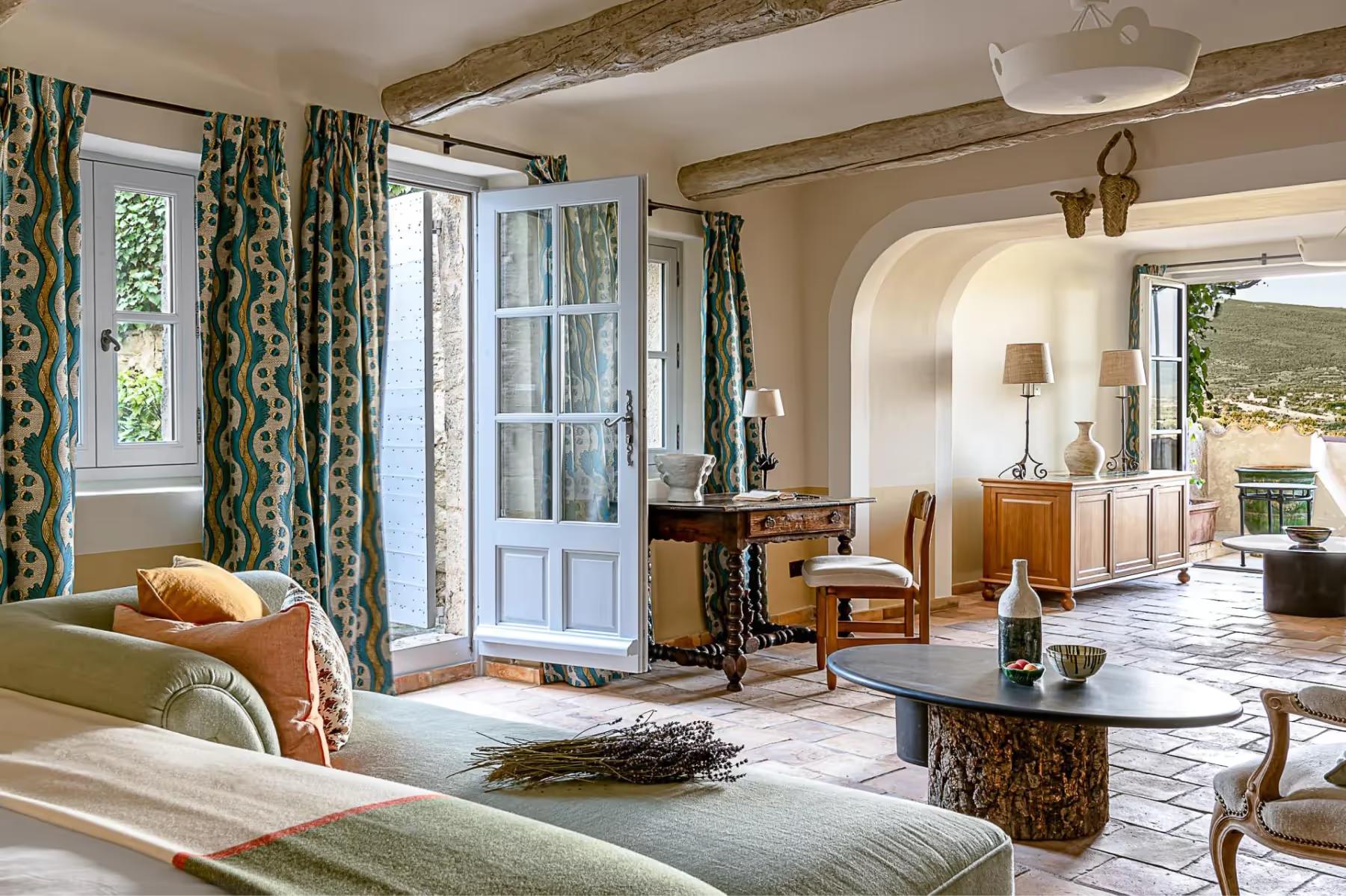 Hôtel Crillon le Brave: a suite with arched doorways, patterned curtains in muted tones, and views through to outdoor areas