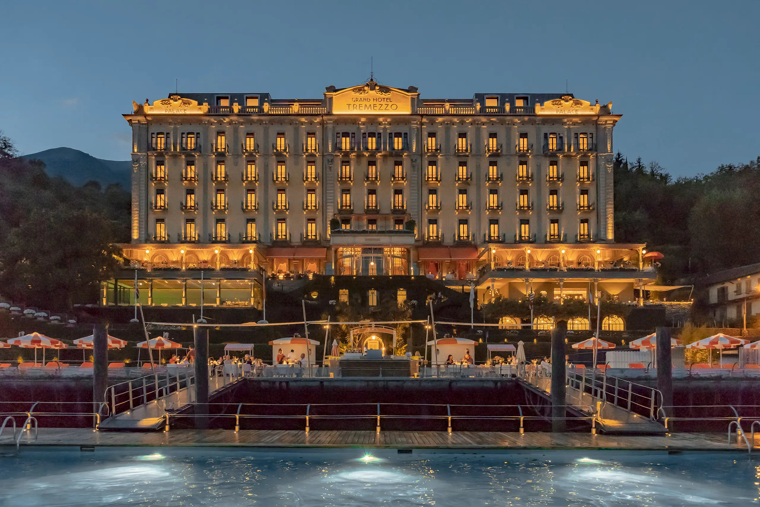 Hotel facade glowing in golden light at dusk with lake foreground