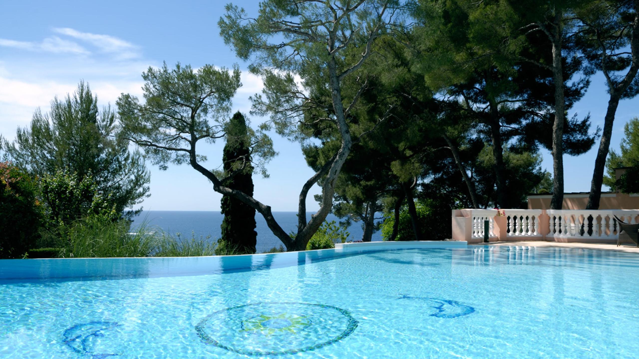 Grand-Hôtel du Cap-Ferrat: pool beneath ancient trees with sea view and manicured grounds