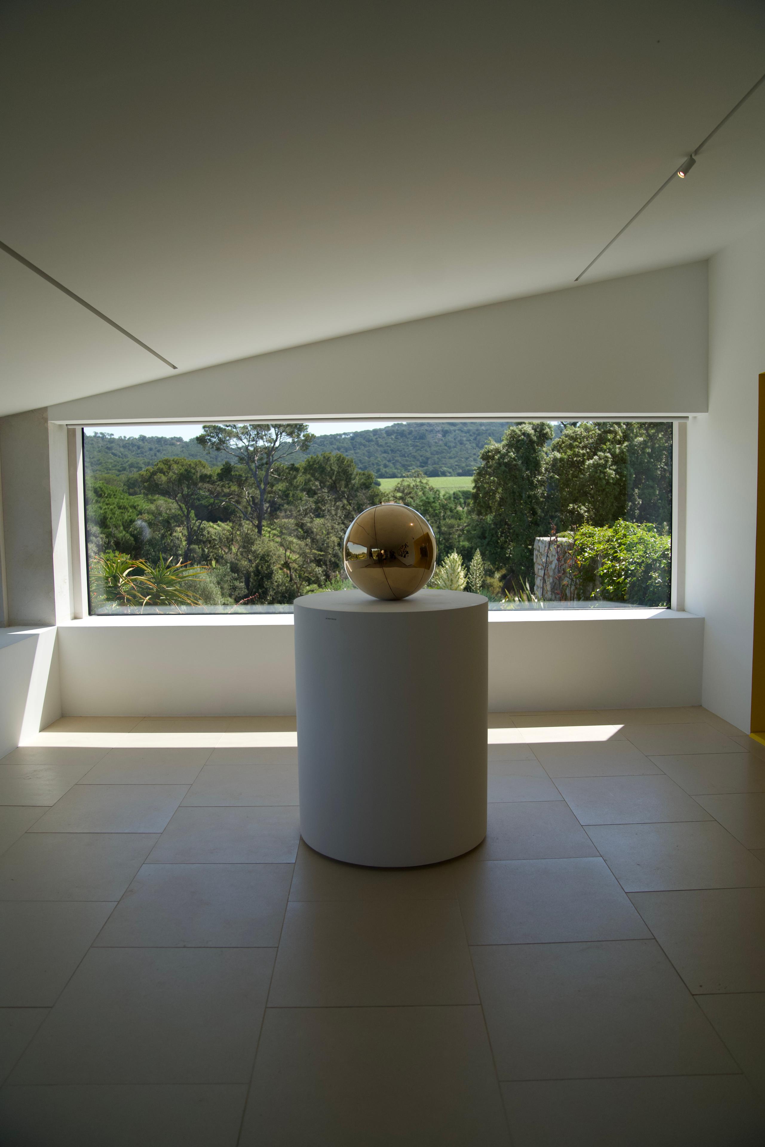 A gilded sphere on a pedestal in the gallery at the Fondation Carmignac
