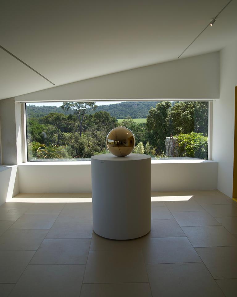 A gilded sphere on a pedestal in the gallery at the Fondation Carmignac