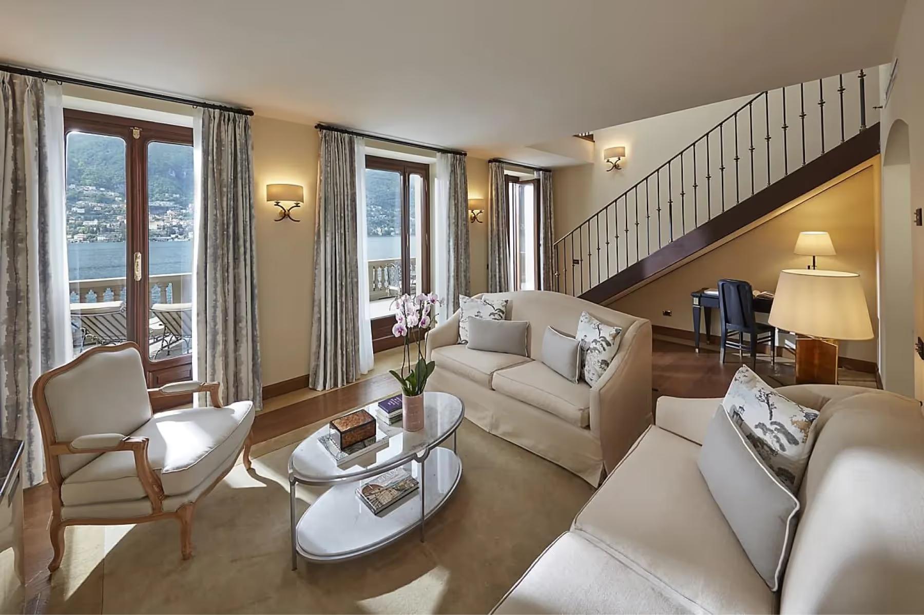 Bright bedroom with full bed, wood furnishings, and glass doors to terrace at dusk