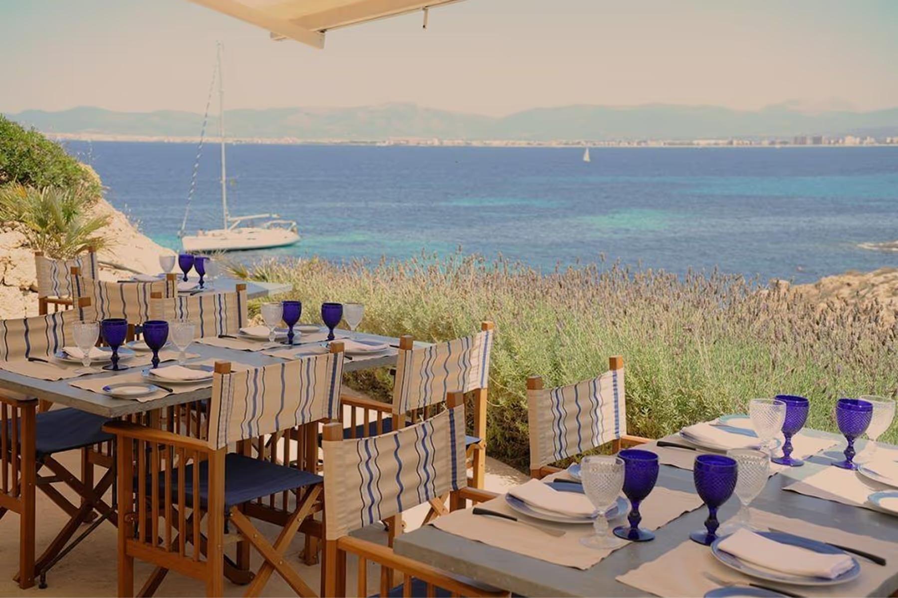 Cap Rocat: an intimate table for two on the beach at dusk, lit by brass lanterns and candlelight