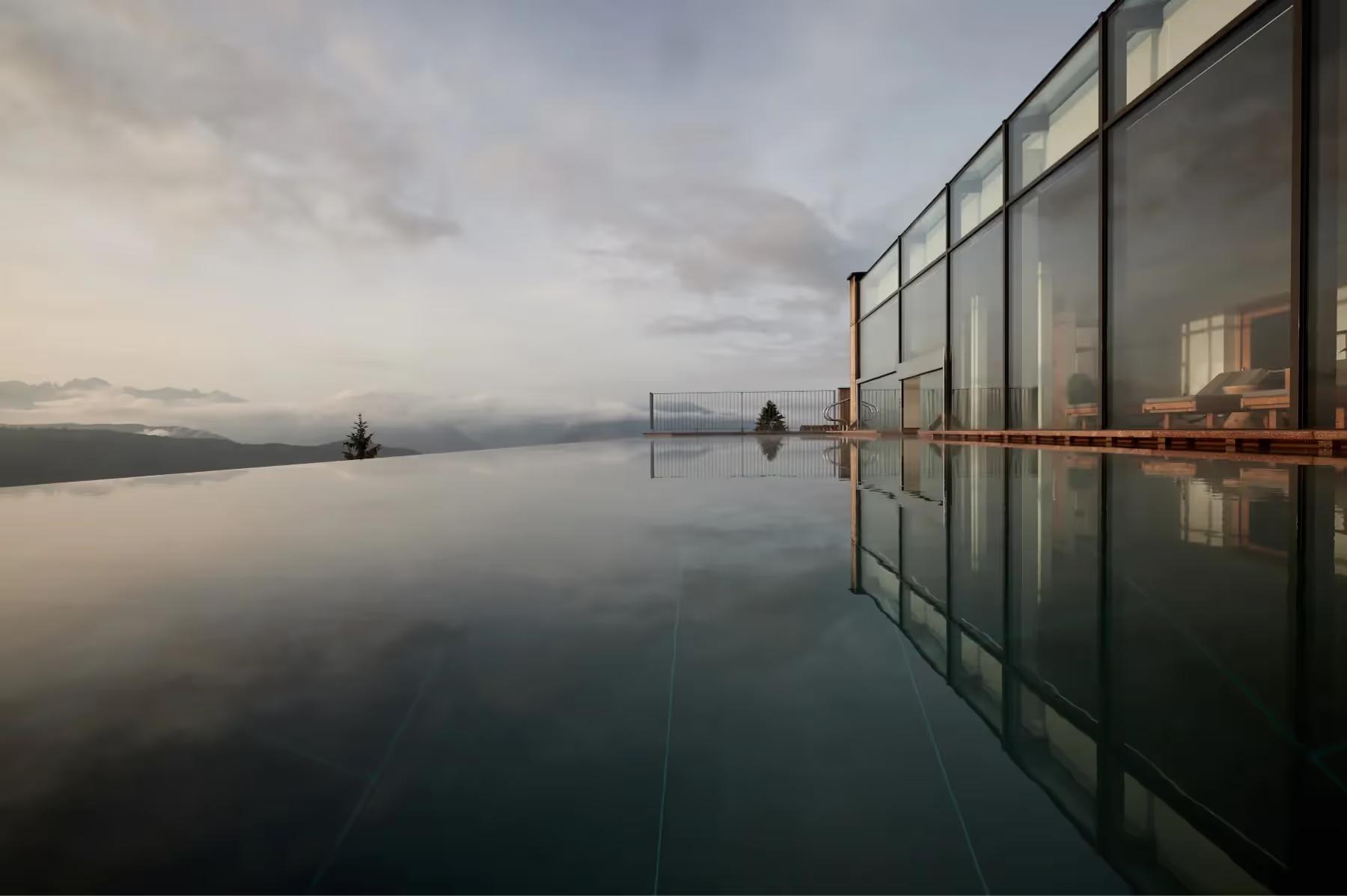 Reflection pool with glass structure overlooking dawn light on distant mountains