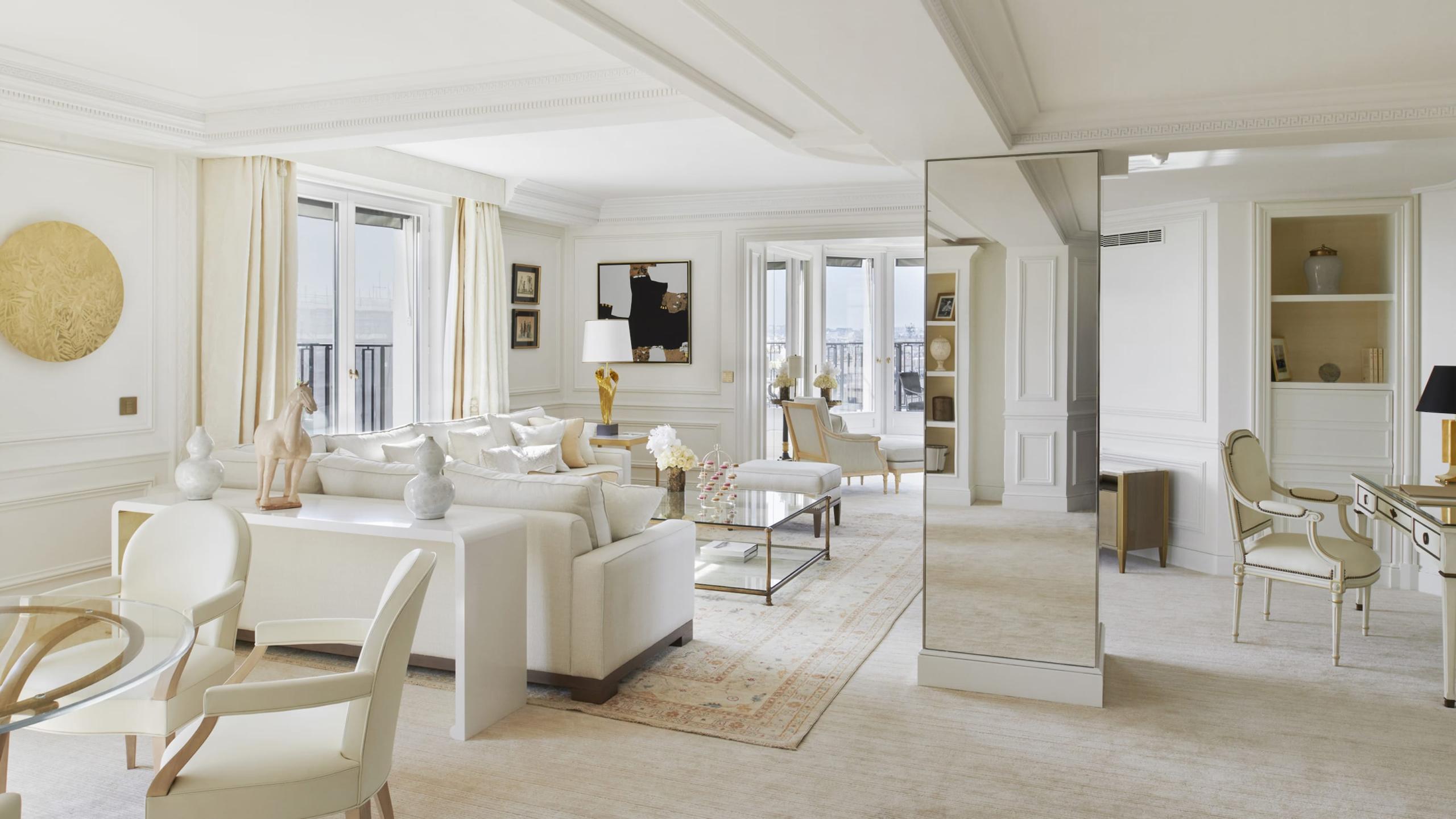 An open suite with mirrors, cream furnishings, and pale wood flooring throughout