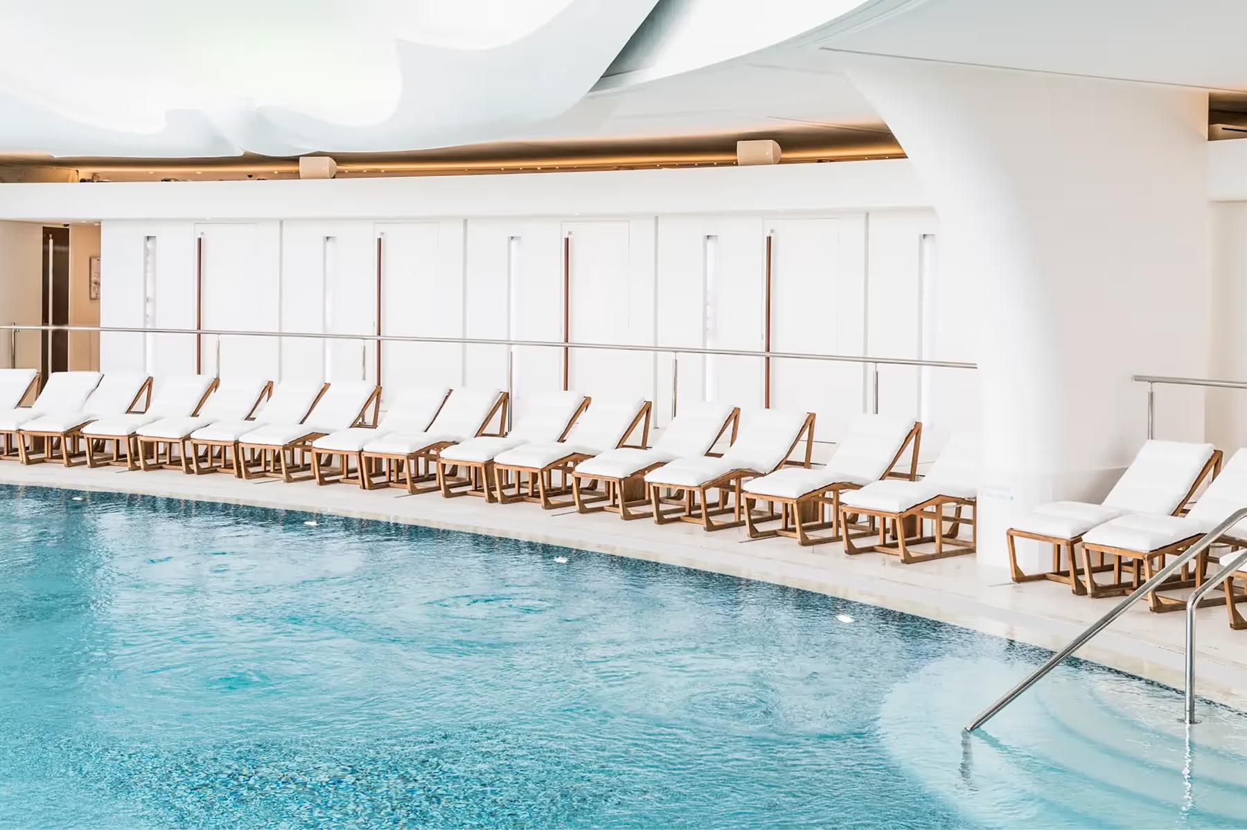 Hôtel Hermitage Monte-Carlo: indoor lap pool with floor-to-ceiling windows and parallel rows of lounge chairs