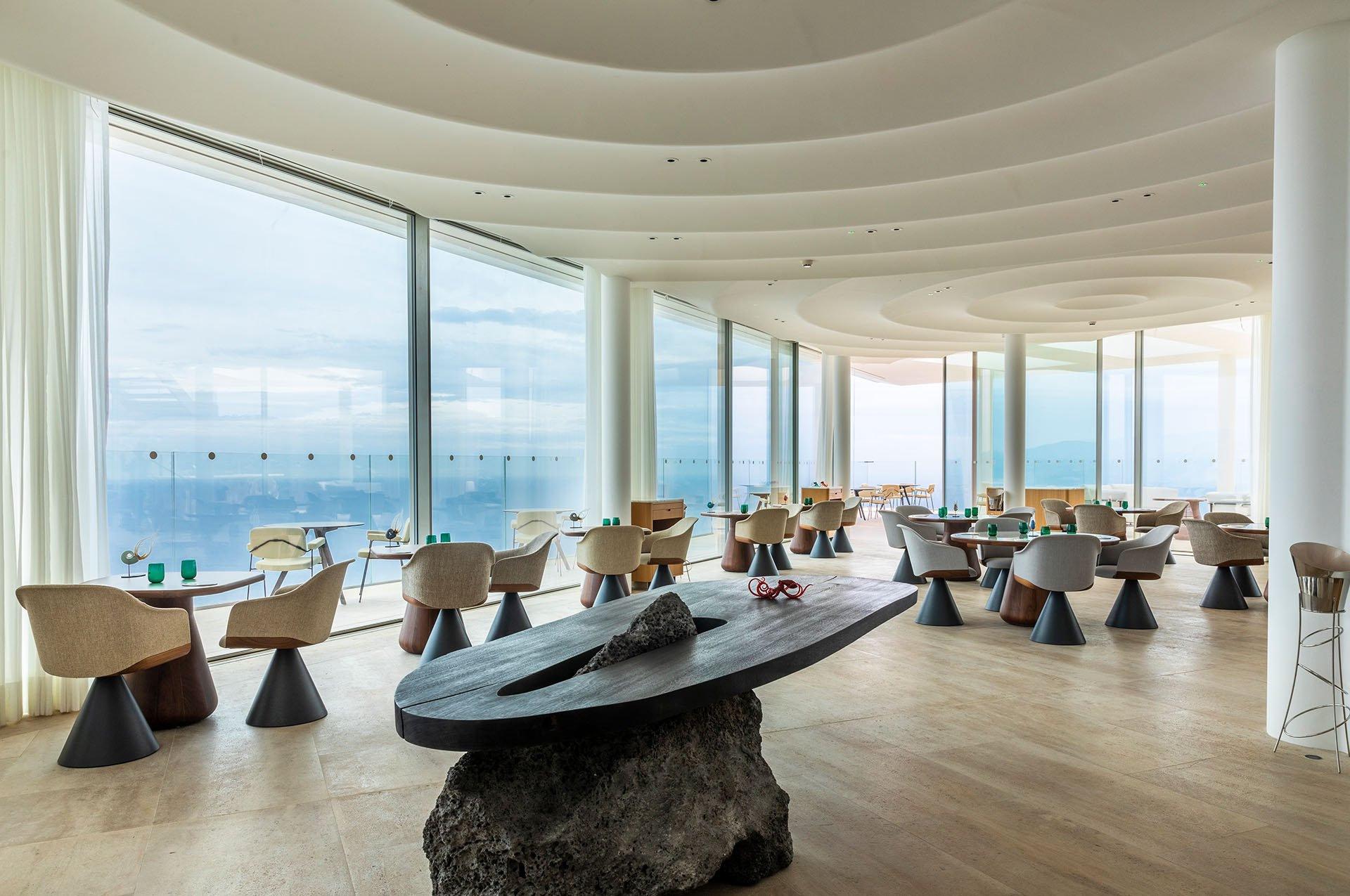 Dining venue with floor-to-ceiling windows and coastal vistas